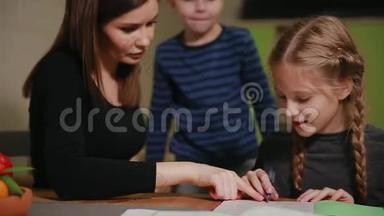 母女俩在做学校<strong>作业</strong>，一个小男孩在看。 哥哥帮忙做<strong>作业</strong>。