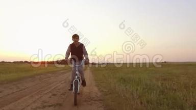 男孩少年骑自行车在大自然的<strong>道路</strong>上。 少年骑自行车到<strong>户外</strong>旅行