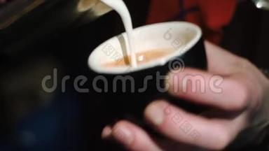 咖啡师把一杯卡布奇诺倒入杯子里，在泡沫上<strong>画出图</strong>案。