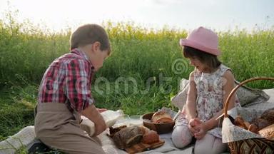 绿色草坪上的朋友，野餐的孩子，大自然中有食物的男孩和女孩，新鲜空气中快乐的孩子，男孩<strong>倒牛奶</strong>