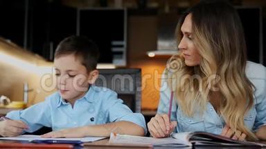 微笑的妈妈帮儿子做作业，口述课文，帮你写坐在厨房的桌子旁。