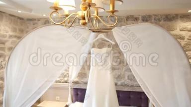 新娘的婚纱挂在床上。 收款o