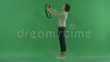一位年轻女子正在绿色屏幕上<strong>左手</strong>边拍照