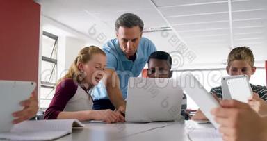 教师协助学童在笔记本电脑4k