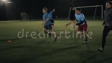 足球运动员在日落球场背景下的动作，足球男子在夜间的职业训练
