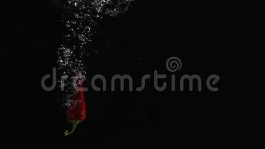 智利辣椒落入水中，在黑色背景下拍摄