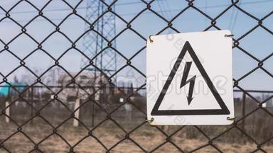 有触电危险.. 围栏后面的变电站。 支架上的高压电线.. 危险警告。