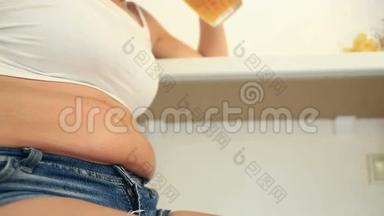 喝啤酒的胖女人。一个穿着短袖T恤和短裤的胖女人正在酒吧里喝加薯条的啤酒。从