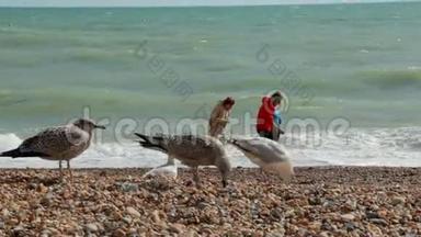 英国布莱顿。 三个暑假的年轻人站在大西洋水附近的海滩上。 那个家伙