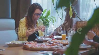 女孩在咖啡馆吃披萨，快餐，慢动作视频，保持智能手机社交媒体。 人们一起吃披萨