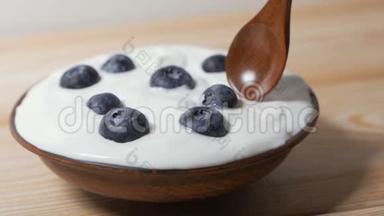 用勺子吃蓝莓和奶油或酸奶。
