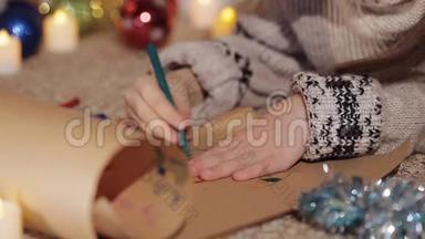 可爱的小女孩躺在圣诞树附近的地板上，画了一张贺卡