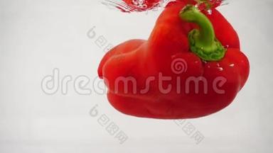 鲜红的甜椒掉入水中，溅起水花和泡泡