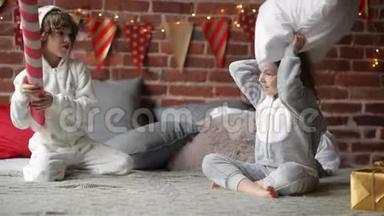 穿着温暖的圣诞睡衣、在家里抱着枕头打架、兄弟姐妹一起在圣诞节玩耍的兄弟姐妹