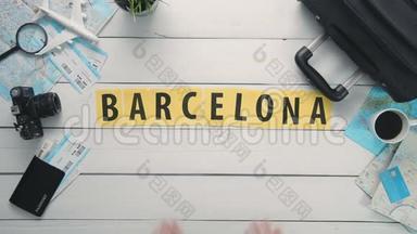 顶部视图时间流逝的手躺在白色的桌子字`BARCELONA`装饰的旅行项目