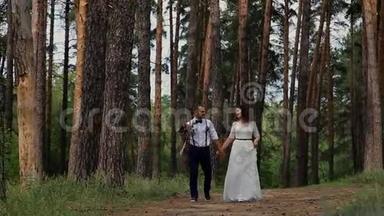 在针叶林中散步的美丽幸福夫妇。在一条林间小路上拍照。互相沟通