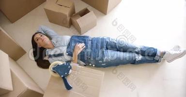 年轻女子收拾行李后在地板上放松