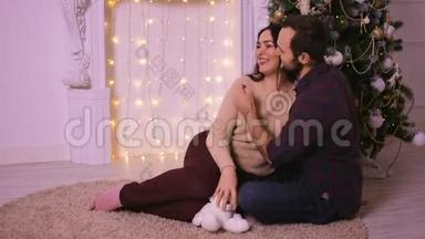 可爱的<strong>情侣</strong>坐在壁炉附近的地毯上。 女人和男人庆祝<strong>圣诞节</strong>。