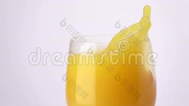 橙片落入一杯橙汁中。