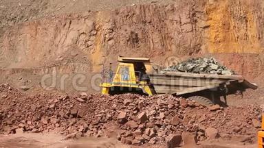 一辆翻<strong>斗车</strong>在一个采石场沿着道路行驶，一辆黄色的采矿自卸卡车，一幅全景图