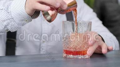 酒吧老板把酒加到酒吧桌上的冰中，酒吧老板用冰块将果汁倒入杯中，