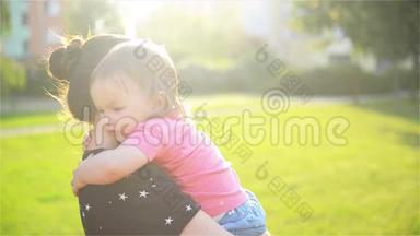 妈妈和孩子在户外拥抱，在大自然中玩得很开心，妈妈拥抱她可爱的小女儿