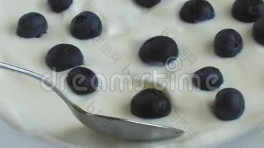 蓝莓浆果白色酸奶用勺子拿出来
