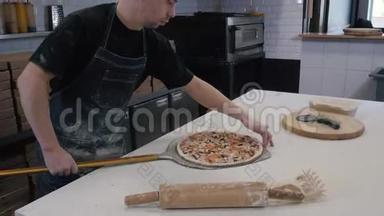 厨师在<strong>烤箱</strong>里准备意大利香肠披萨，从后面看。 跟着。 在<strong>烤箱</strong>里做饭。