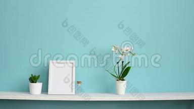 相框模型。 用盆栽兰花和手插做的白色架子搭在粉绿色墙上