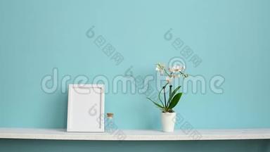 相框模型。 用盆栽兰花和手插做的白色架子搭在粉绿色墙上