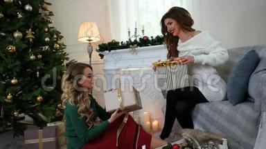女朋友在圣诞树附近的新年节日、女人在谈笑风生的时候，收拾好礼物的盒子
