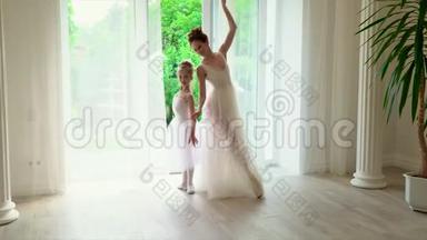 芭蕾舞老师和女学生在窗口跳舞。 美丽的芭蕾舞演员在白色芭蕾舞学校跳舞