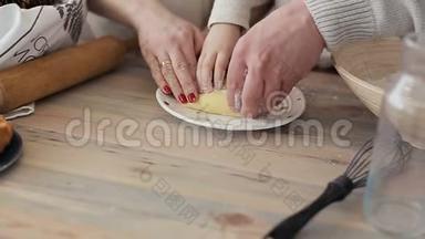 微笑的一家人在厨房柜台边做圣诞饼干边玩饼干粉。烤饼干和松饼