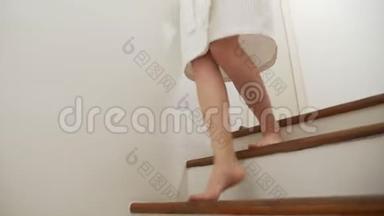 特写镜头。 女腿上升到木梯的顶部。 穿着晨衣的女人走上台阶