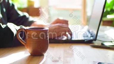 有笔记本电脑的咖啡馆里的男人。 关注热茶这一杯.. 人端茶喝.. 只有<strong>没有</strong>脸的手