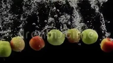 成熟的水果绿色和红色的苹果<strong>落入</strong>水中，黑色的背景