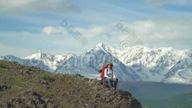 旅行者坐在山顶的女人，从<strong>热水</strong>瓶里<strong>喝</strong>热茶。 红色背包，橙色夹克。 草帽。 筷子