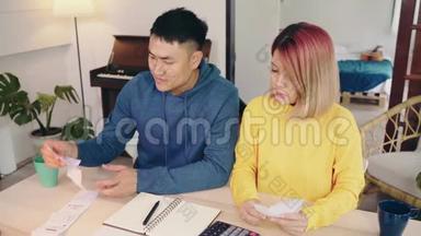 <strong>年轻时</strong>强调，亚洲夫妇管理财务，在现代家庭使用笔记本电脑和计算器审查他们的银行账户。