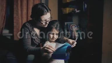 小女孩和一个成年女人正在读一本书，他们在晚上被教一个<strong>睡前</strong>故事。 母亲和