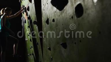 一名女子攀爬者的手特写，她沿着墙壁爬上攀爬墙，在没有比赛的情况下绊倒