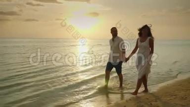 浪漫的<strong>情侣</strong>在日落时在海边散步。 <strong>蜜月</strong>和海边度假的概念