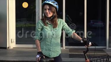 在自行车上工作的主题。 一位年轻的高加索女人骑着环保的交通自行车来到办公室