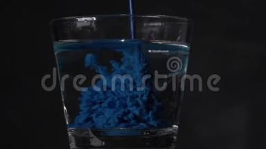 蓝色液体倒入清<strong>水中</strong>.. 蓝色墨水被溶解在一杯<strong>水中</strong>，并创造了抽象的背景。