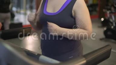 肥胖的年轻女人在跑步机上跑步，<strong>努力</strong>减肥