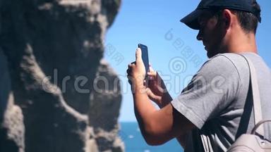 一个戴着帽子的<strong>游客</strong>拍了一张靠近大海的美丽悬崖的照片。 <strong>高清</strong>，1920x1080。 慢动作。