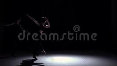 开始两个舞者在黑色，阴影，慢动作的优美现代舞蹈
