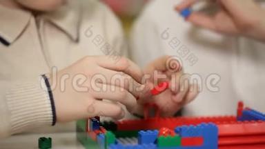 在玩具展览会上，两个男孩玩儿童`塑料积木