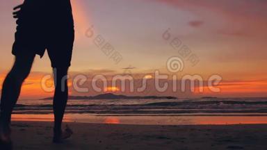 幸福的情侣在夕阳西下的海边相遇并前往海滩的慢动作剪影