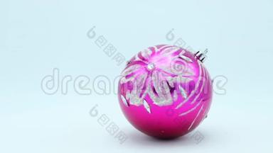 圣诞节粉红色的球，银光闪闪的花在白色的背景上旋转。