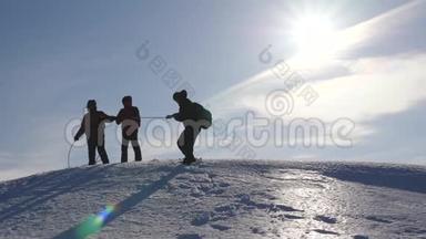 登山队员在冬天从山上下来绳子. 旅行者用绳子从一座雪山上下来。 协调良好的团队合作